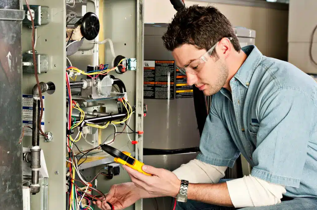 HVAC Technician Looking at Inside of Furnace