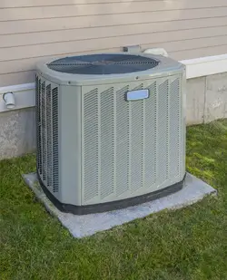An HVAC Condenser on a grey concrete slab 
