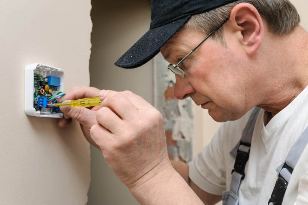 An HVAC Technicien Working on a Thermostat